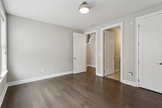 unfurnished bedroom featuring baseboards and wood-type flooring