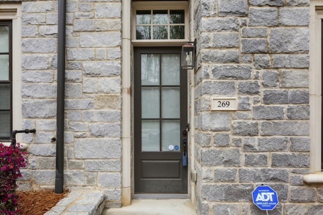 property entrance featuring stone siding