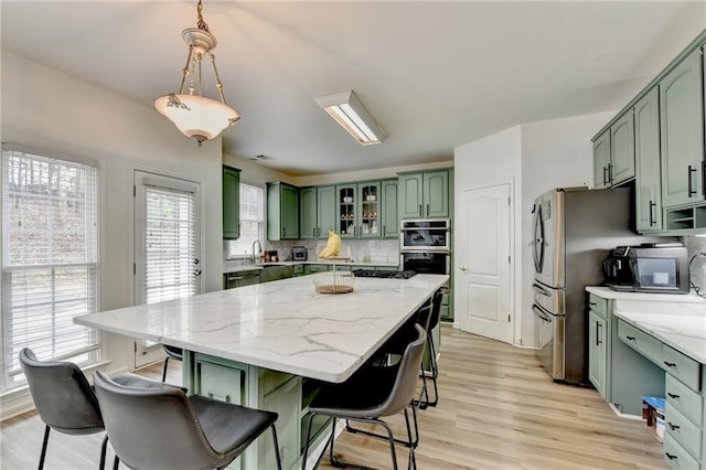 kitchen featuring tasteful backsplash, a breakfast bar, and green cabinetry