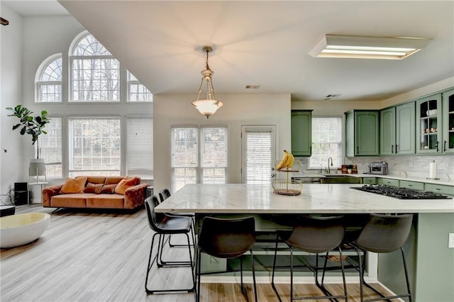 kitchen featuring plenty of natural light, a breakfast bar area, and green cabinets