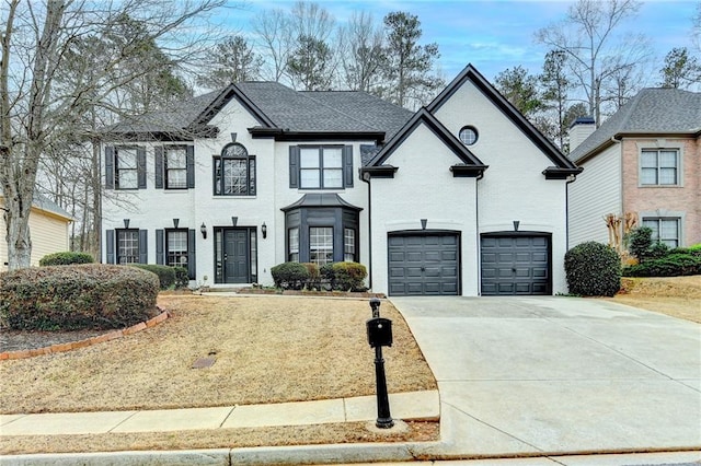 view of front of house featuring a garage, brick siding, and driveway