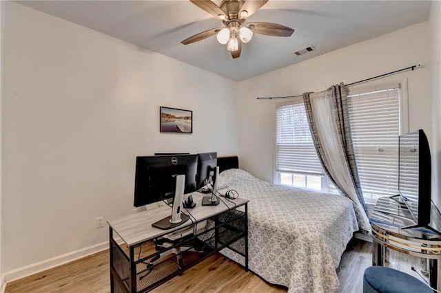 bedroom with visible vents, baseboards, light wood-style floors, and a ceiling fan