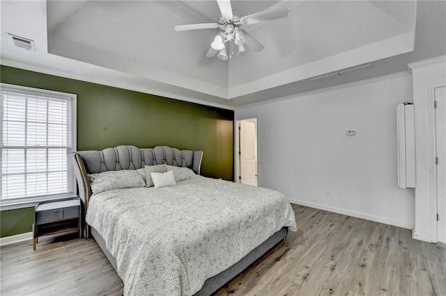 bedroom with visible vents, a raised ceiling, and baseboards