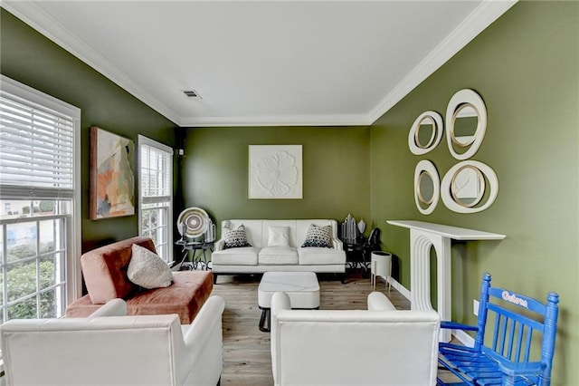 living area featuring visible vents, wood finished floors, and ornamental molding