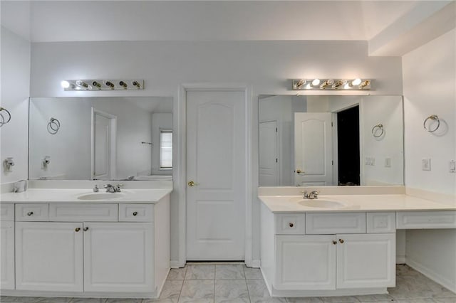 bathroom featuring two vanities, marble finish floor, and a sink