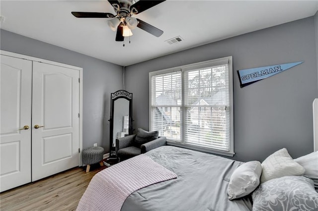 bedroom featuring visible vents, a ceiling fan, and light wood finished floors