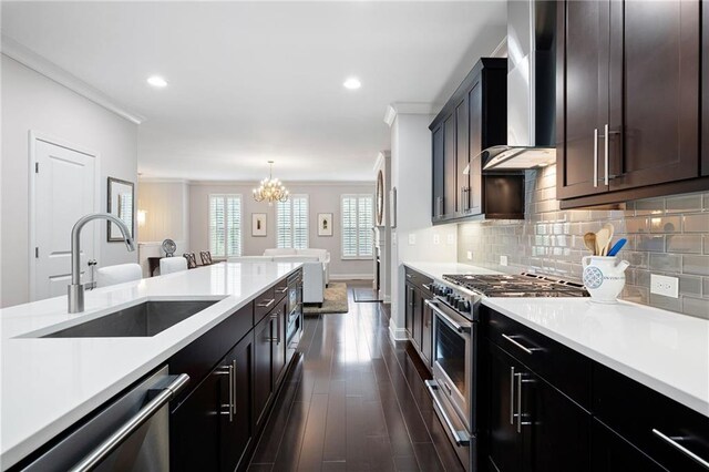 kitchen with crown molding, appliances with stainless steel finishes, sink, dark wood-type flooring, and wall chimney exhaust hood