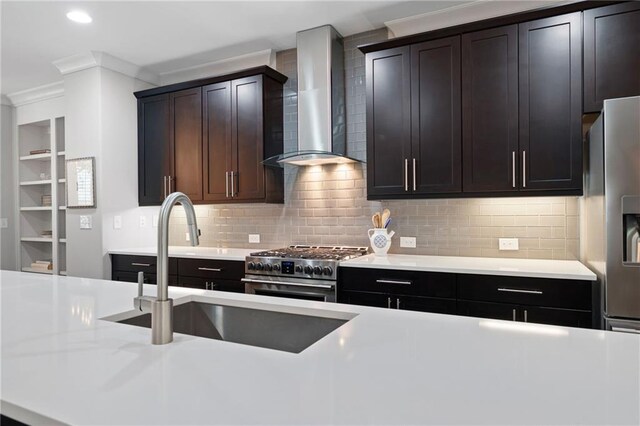 kitchen with dark brown cabinetry, wall chimney exhaust hood, tasteful backsplash, stainless steel range, and crown molding