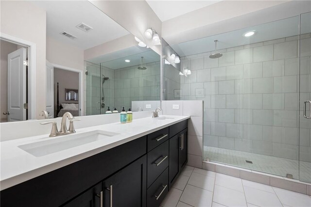 bathroom featuring vanity, a shower with door, and tile patterned floors