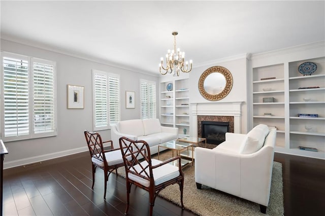 living room featuring a fireplace, dark wood-type flooring, crown molding, and an inviting chandelier