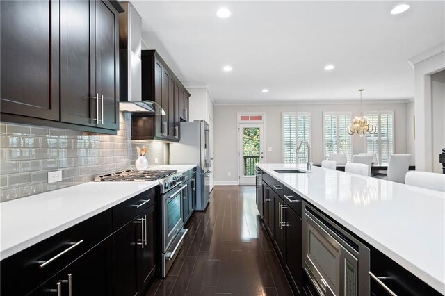 kitchen with sink, appliances with stainless steel finishes, crown molding, dark wood-type flooring, and pendant lighting