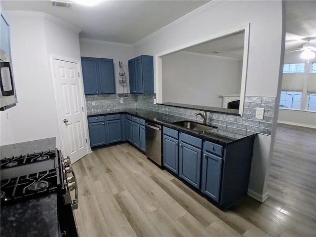 kitchen featuring a sink, blue cabinetry, backsplash, crown molding, and gas range