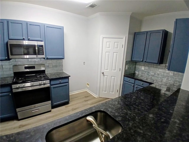 kitchen with stainless steel appliances, visible vents, crown molding, and dark stone counters