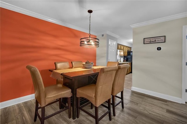 dining room featuring a chandelier, hardwood / wood-style flooring, and crown molding