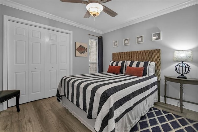 bedroom with hardwood / wood-style flooring, ceiling fan, ornamental molding, and a closet