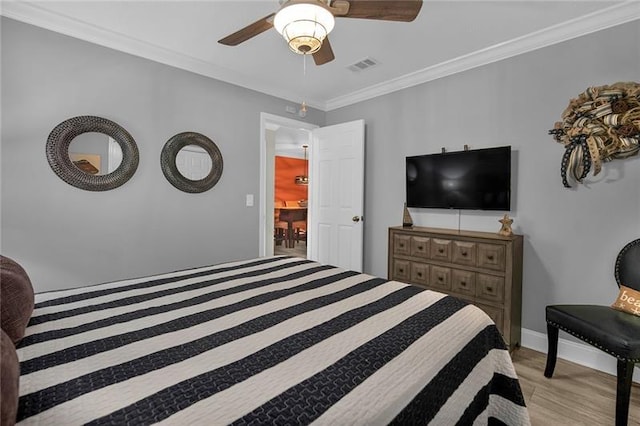 bedroom featuring crown molding, ceiling fan, and light hardwood / wood-style floors