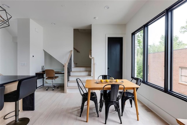 dining area with light wood-style floors, stairs, and recessed lighting