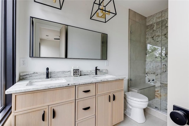 bathroom featuring a stall shower, toilet, double vanity, and tile patterned floors