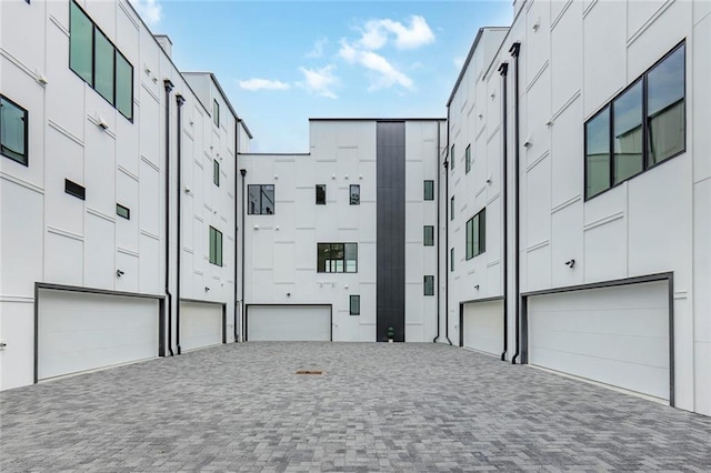 view of building exterior with an attached garage and driveway