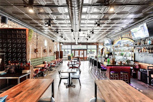dining area featuring concrete floors, a dry bar, and an ornate ceiling