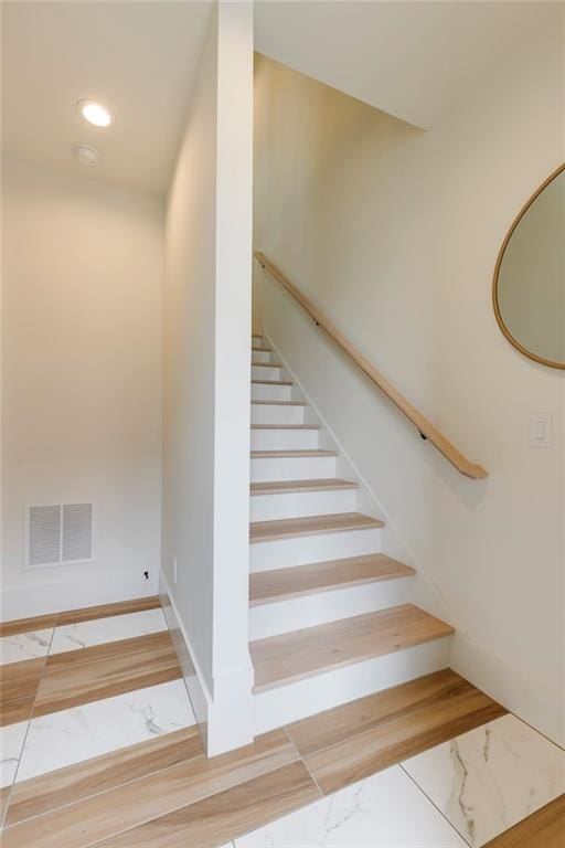 stairs with marble look tiles and baseboards