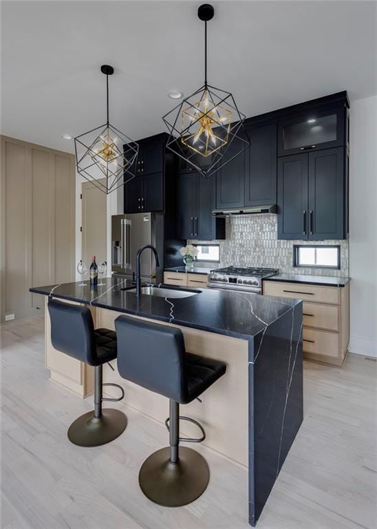 kitchen with stainless steel appliances, a chandelier, a sink, and light wood-type flooring