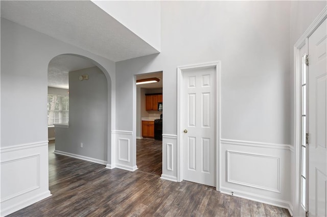 interior space with a textured ceiling and dark hardwood / wood-style floors