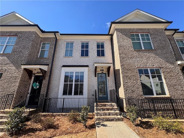 townhome / multi-family property with fence and brick siding