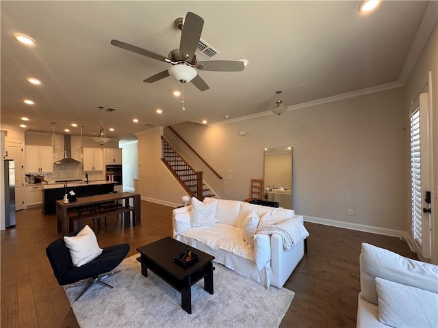 living area with baseboards, stairway, and ornamental molding