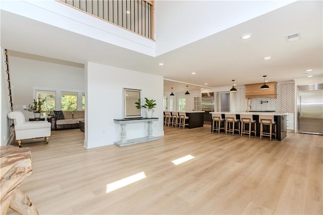 living room with light wood-type flooring and a high ceiling