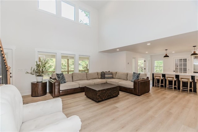 living room featuring a high ceiling and light wood-type flooring