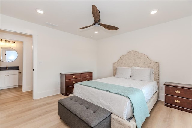 bedroom with ensuite bath, ceiling fan, and light hardwood / wood-style flooring