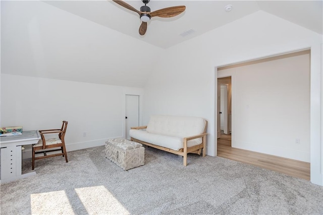 living area with ceiling fan, light colored carpet, and lofted ceiling