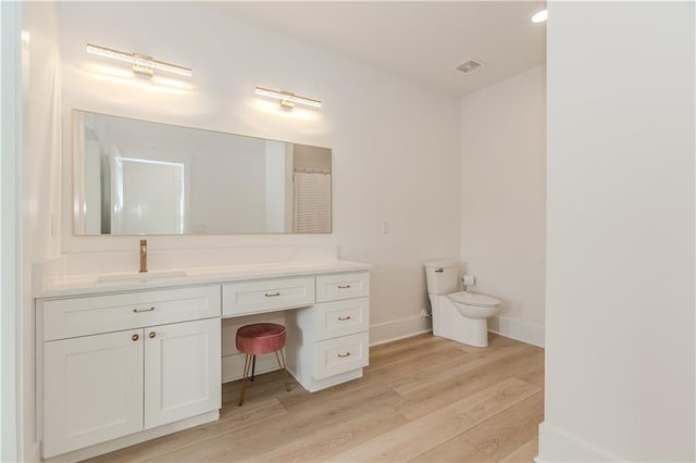 bathroom with vanity, toilet, and wood-type flooring