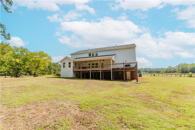 back of property with a rural view, a wooden deck, and a lawn