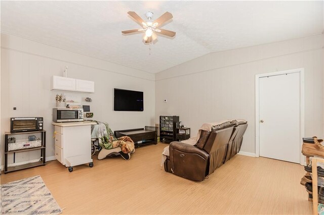 living room with light wood-type flooring, vaulted ceiling, and ceiling fan