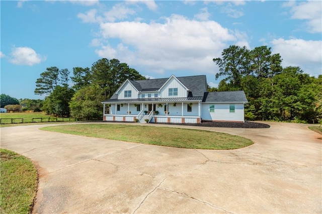 farmhouse with covered porch and a front yard