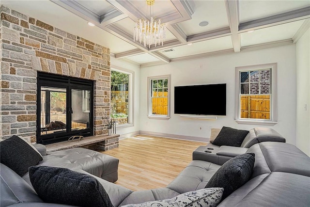 living room featuring hardwood / wood-style floors, beam ceiling, an inviting chandelier, coffered ceiling, and a stone fireplace