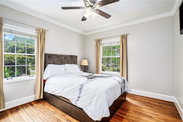 bedroom with ceiling fan, hardwood / wood-style floors, and ornamental molding