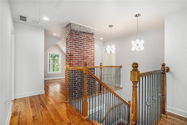 corridor with a chandelier and hardwood / wood-style floors