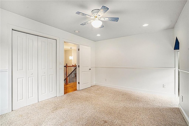 unfurnished bedroom featuring ceiling fan, a closet, and carpet flooring