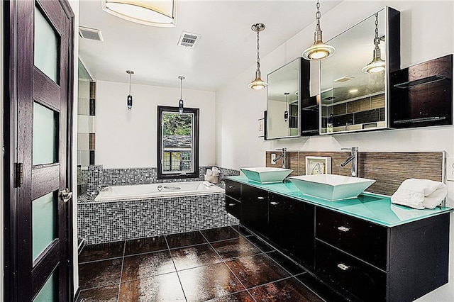 bathroom featuring vanity and tiled tub