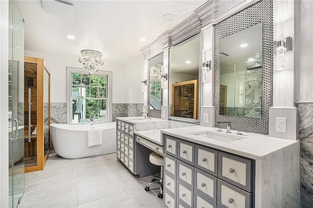 bathroom with tile patterned flooring, vanity, an inviting chandelier, tile walls, and independent shower and bath