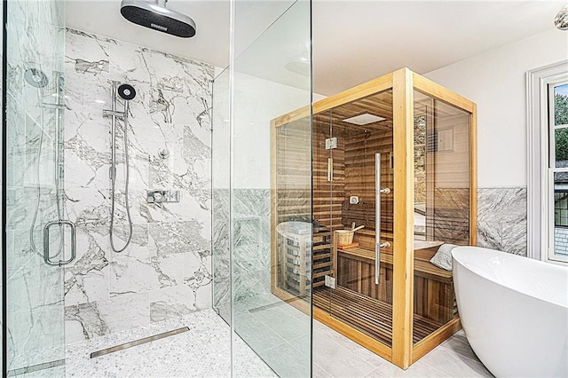 bathroom with tile walls and independent shower and bath