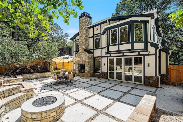 rear view of property with a patio area and a fire pit