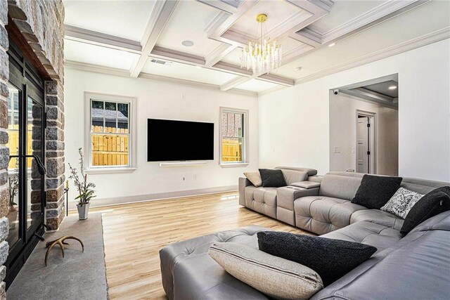 living room with a wealth of natural light, beamed ceiling, an inviting chandelier, coffered ceiling, and light hardwood / wood-style flooring