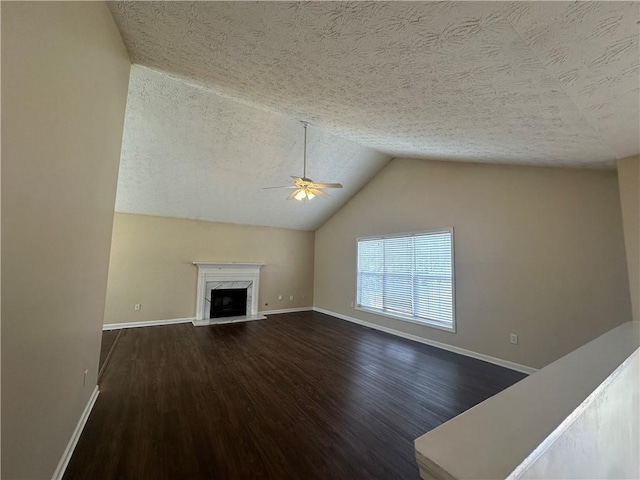 unfurnished living room with lofted ceiling, a textured ceiling, a premium fireplace, wood finished floors, and baseboards