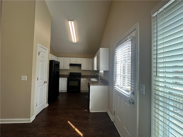 kitchen with under cabinet range hood, dark wood-type flooring, a sink, white cabinetry, and black appliances