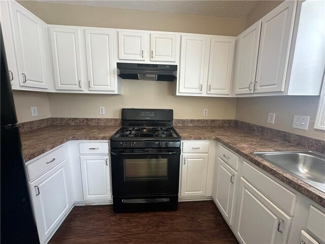 kitchen featuring black appliances, under cabinet range hood, white cabinets, and a sink