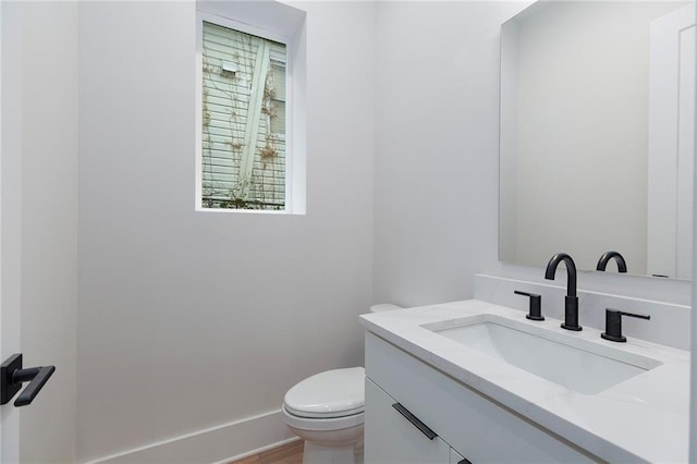 bathroom featuring vanity, toilet, and wood-type flooring